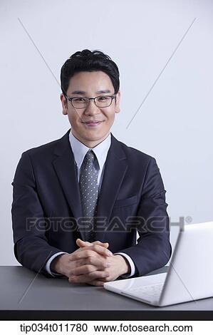 a businessman smiling with a laptop on the desk View Large Photo Image Stock Image - a businessman smiling with a laptop on the desk. Fotosearch