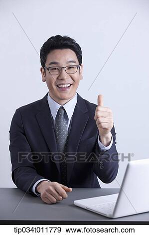 a businessman smiling with a laptop on the desk View Large Photo Image Stock Photo - a businessman smiling with a laptop on the desk. Fotosearch