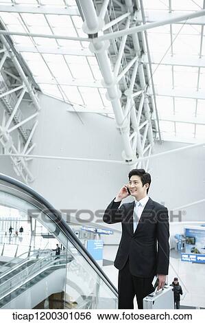 a businessman taking escalator in the airport View Large Photo Image Stock Photograph - a businessman taking escalator in the airport. Fotosearch
