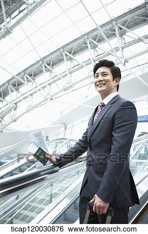 a businessman taking escalator in the airport View Large Photo Image Stock Photograph - a businessman taking escalator in the airport. Fotosearch