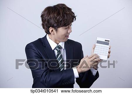 a businessman using a calculator View Large Photo Image Stock Image - a businessman using a calculator. Fotosearch