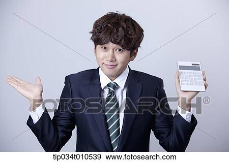 Stock Photo - a businessman using a calculator. Fotosearch