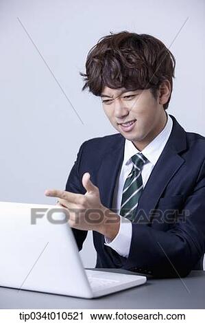 Stock Image - a businessman using a laptop. Fotosearch