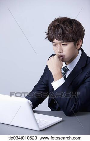 Stock Image - a businessman using a laptop. Fotosearch