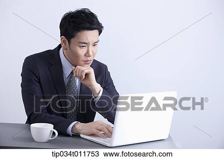 Stock Image - a businessman using a laptop. Fotosearch