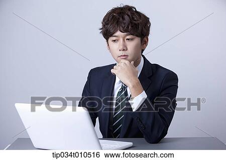 Stock Photograph - a businessman using a laptop. Fotosearch