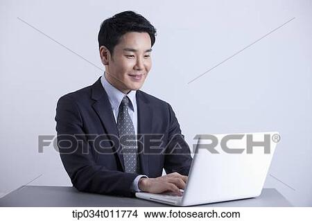 Picture - a businessman using laptop smiling . Fotosearch
