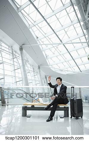 a businessman using laptop while sitting on a bench in the airport View Large Photo Image Stock Image - a businessman using laptop while sitting on a bench in the airport. Fotosearch