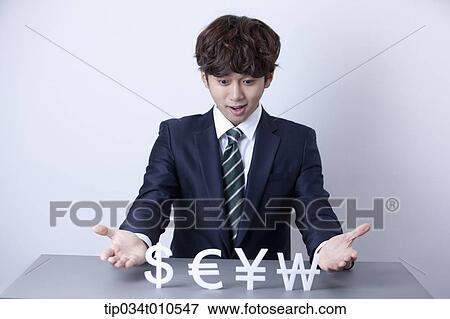 Stock Photo - a businessman with currency blocks. Fotosearch