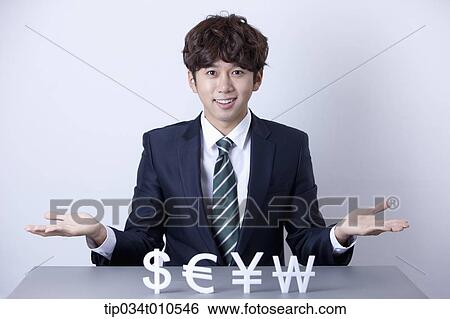 Stock Photograph - a businessman with currency blocks. Fotosearch