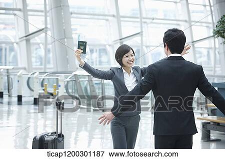 a businesswoman and businessman about to hug each other in the airport View Large Photo Image Stock Photo - a businesswoman and businessman about to hug each other in the airport. Fotosearch
