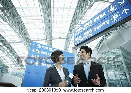 a businesswoman and businessman having a chat in the airport View Large Photo Image Stock Image - a businesswoman and businessman having a chat in the airport. Fotosearch