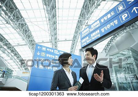 a businesswoman and businessman having a chat in the airport View Large Photo Image Stock Image - a businesswoman and businessman having a chat in the airport. Fotosearch