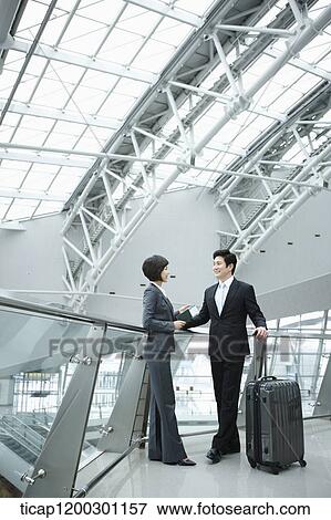 a businesswoman and businessman having a chat in the airport View Large Photo Image Stock Photo - a businesswoman and businessman having a chat in the airport. Fotosearch