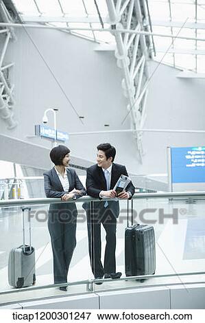 a businesswoman and businessman having a chat in the airport View Large Photo Image Stock Photo - a businesswoman and businessman having a chat in the airport. Fotosearch