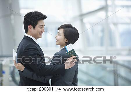 a businesswoman and businessman hugging each other in the airport View Large Photo Image Picture - a businesswoman and businessman hugging each other in the airport. Fotosearch