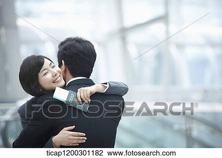 a businesswoman and businessman hugging each other in the airport View Large Photo Image Stock Image - a businesswoman and businessman hugging each other in the airport. Fotosearch