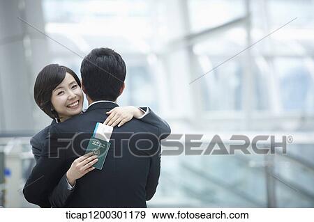 a businesswoman and businessman hugging each other in the airport View Large Photo Image Stock Photo - a businesswoman and businessman hugging each other in the airport. Fotosearch