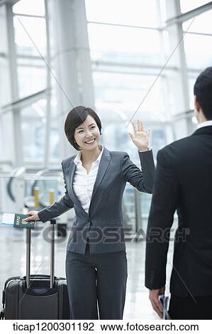 a businesswoman and businessman saying hi to each other in the airport View Large Photo Image Stock Image - a businesswoman and businessman saying hi to each other in the airport. Fotosearch