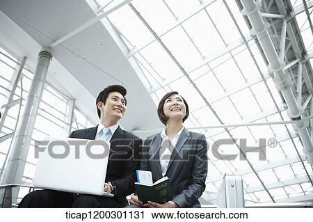 a businesswoman and businessman using laptop in the airport View Large Photo Image Stock Image - a businesswoman and businessman using laptop in the airport. Fotosearch