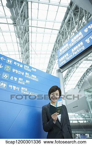 a businesswoman standing in front of a information board in the airport View Large Photo Image Stock Photograph - a businesswoman standing in front of a information board in the airport. Fotosearch