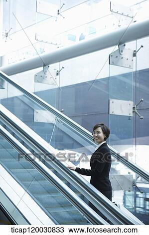 a businesswoman taking escalator in the airport View Large Photo Image Stock Image - a businesswoman taking escalator in the airport. Fotosearch
