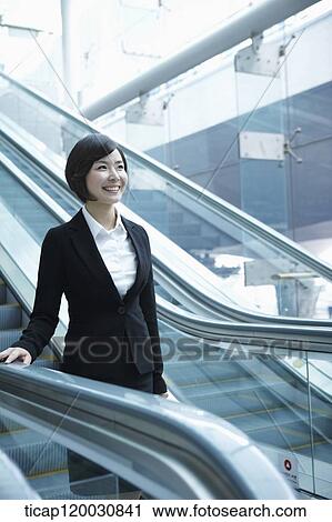 a businesswoman taking escalator in the airport View Large Photo Image Stock Image - a businesswoman taking escalator in the airport. Fotosearch