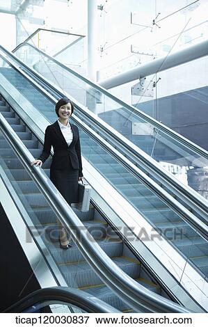 a businesswoman taking escalator in the airport View Large Photo Image Stock Photo - a businesswoman taking escalator in the airport. Fotosearch