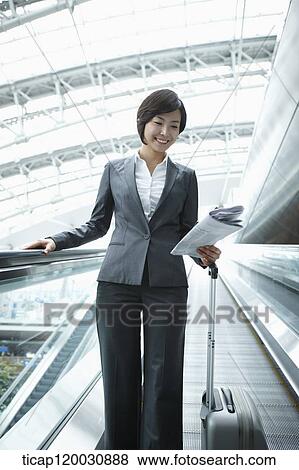 a businesswoman taking escalator in the airport View Large Photo Image Stock Photo - a businesswoman taking escalator in the airport. Fotosearch