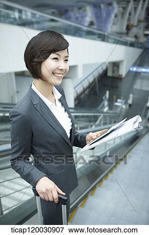 a businesswoman taking escalator in the airport View Large Photo Image Stock Photo - a businesswoman taking escalator in the airport. Fotosearch