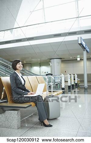 a businesswoman using laptop in the airport View Large Photo Image Stock Image - a businesswoman using laptop in the airport. Fotosearch