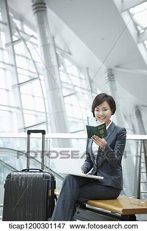 a businesswoman using laptop while sitting on a bench in the airport View Large Photo Image Stock Photo - a businesswoman using laptop while sitting on a bench in the airport. Fotosearch