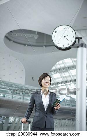 a businesswoman walking with a suitcase in the airport View Large Photo Image Picture - a businesswoman walking with a suitcase in the airport. Fotosearch