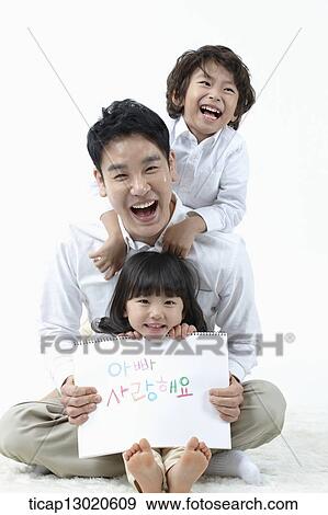 a daughter sitting in fathers lap and holding a notebook View Large Photo Image Stock Photo - a daughter sitting in fathers lap and holding a notebook. Fotosearch