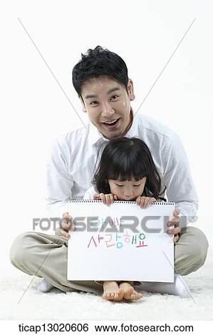 a daughter sitting in fathers lap and holding a notebook View Large Photo Image Stock Photograph - a daughter sitting in fathers lap and holding a notebook. Fotosearch