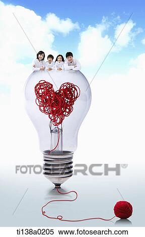 Stock Photography - a family lying on a light bulb. Fotosearch