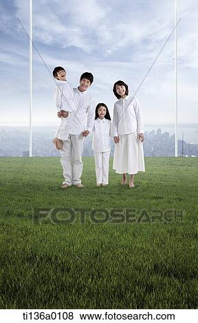 a family standing on grass View Large Photo Image Stock Photo - a family standing on grass. Fotosearch