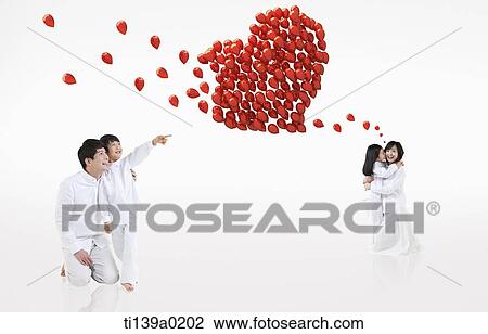 Stock Image - a family with a heart of balloons. Fotosearch