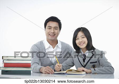 Picture - a father helping daughter with homework. Fotosearch