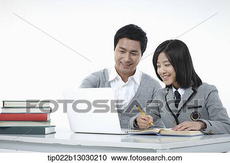 Stock Image - a father helping daughter with homework. Fotosearch