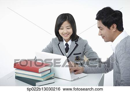 Stock Photograph - a father helping daughter with homework. Fotosearch