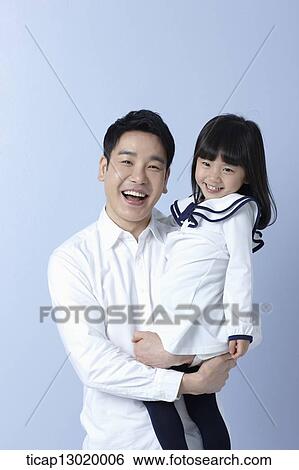 a father holding daughter in blue background View Large Photo Image Stock Photograph - a father holding daughter in blue background. Fotosearch