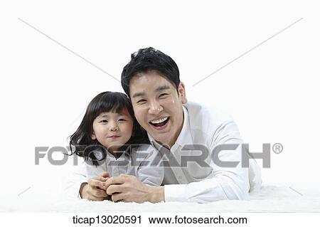 Stock Image - a father lying on the floor with his daughter. Fotosearch