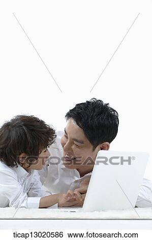a father lying on the floor with his son while playing on laptop View Large Photo Image Stock Photograph - a father lying on the floor with his son while playing on laptop. Fotosearch