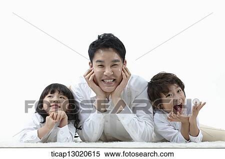 Stock Photography - a father lying on the floor with his kids. Fotosearch