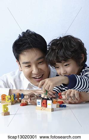 Stock Image - a father playing with his son. Fotosearch