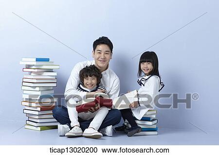 Stock Image - a father reading books with his kids. Fotosearch