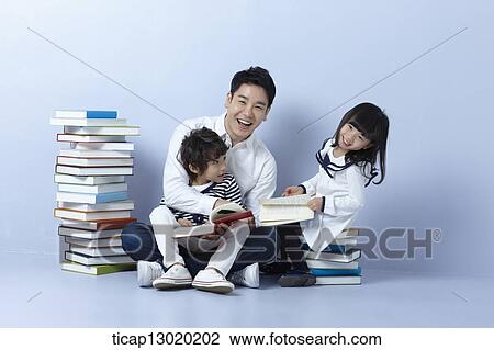 Stock Image - a father reading books with his kids. Fotosearch