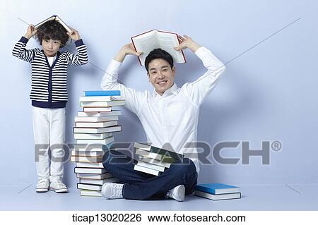 Stock Photograph - a father reading books with his son. Fotosearch