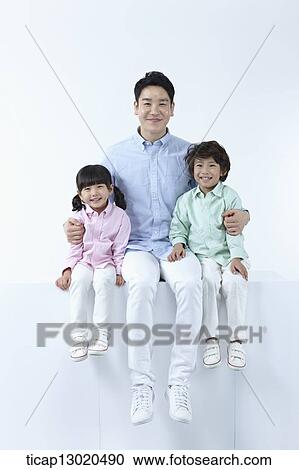 Stock Image - a father sitting with his kids. Fotosearch